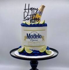 a birthday cake with a bottle of modelo beer and limes on top is shown