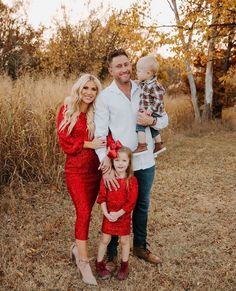 a man and woman with two children posing for a family photo in the fall leaves