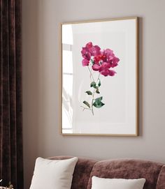 a living room with a couch, coffee table and framed flower art on the wall