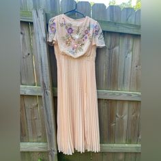 This Dress Is Beautiful. I Bought It To Wear To My Goddaughter’s Wedding But All Of Her Bridesmaids Were In Florals. It Is A Light Peachy Color With Gorgeous Embroidered Flowers. It Has Butterfly Sleeves, A Full Peach Lining With A Sheer Overlay. The Bodice Is Embroidered And Cowl Neck With A Pleated Skirt. Measurements: Arm Pit To Arm Pit: 18”, Shoulder To Hemline 53”, Front Waistline: 15”. Peach Party Dress With Floral Embroidery, Embroidered Fitted Bridesmaid Dresses, Fitted Embroidered Bridesmaid Dresses, Fitted Embroidered Dresses For Bridesmaids, Bridesmaid Dresses With Embroidered Fitted Design, Peach Spring Wedding Dress, Fitted Peach Dress With Floral Embroidery, Embroidered Peach Dress For Party, Fitted Peach Dress For Wedding