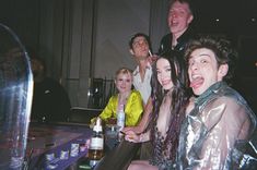 a group of people sitting at a table with bottles and drinks in front of them