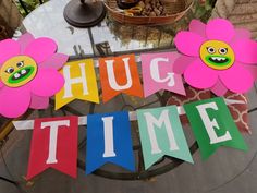 a sign that says hug time with two flowers on it and the words hug time written in large letters