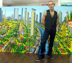 a man standing in front of a painting on the wall with buildings and palm trees