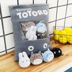 an assortment of totoro stuffed animals in a bag on a shelf next to other toys