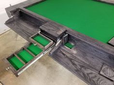 a wooden table with green felt in the middle and two drawers on each side that are open