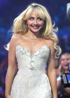 a blonde woman in a white dress on stage