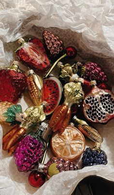 a bag filled with lots of different types of ornaments on top of white tissue paper