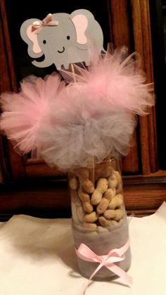 a vase filled with peanuts and pink tulle