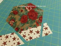 a piece of fabric with red flowers and stars on it next to a cutting board