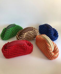 four beaded purses sitting on top of a white table