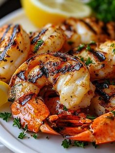 grilled shrimp on a plate with lemon wedges and parsley garnish