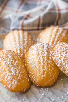 some sugared pastries are on a glass plate