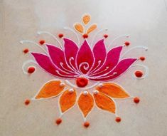 a pink and orange flower on a white surface with red dots around it, surrounded by small beads