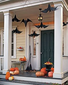 a porch decorated for halloween with pumpkins and bats