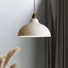 a white lamp hanging from a ceiling next to a window