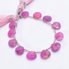 a pink bracelet with tassels and beads