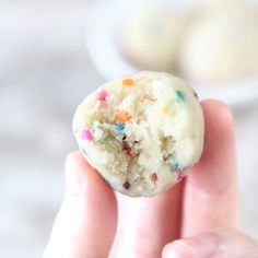 a hand holding a half eaten cookie with sprinkles