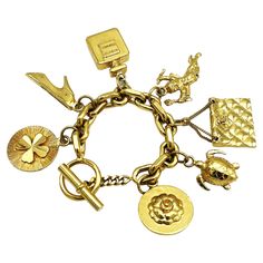 Chanel's gold-tone chain link bracelet with seven iconic Chanel items hung from the chain such as a shamrock, heels, a perfume bottle, cupid, a quilted Chanel bag and a turtle, a camellia, Coco Chanel's favorite flower! All iconic charms are almost identical on both sides and 24k gold plated. Measurement: The bracelet has a length of 20 cm, Size of the charms, the quilted pocket 3.5 x 2.5 cm, perfume bottle 3.5 x 2.5 cm, camelliar 3 cm, locking ring 2 cm, toggle 3.5 cm Features: - Material solid and gilded, - Signed 'CHANEL' on the clasp ring through which the toggle is inserted. - 7 iconic Chanel charms. - Excellent vintage condition - Chanel Items, Quilted Pocket, Chanel Pendant, Lucky Charm Bracelet, Favorite Flower, Gold Charm Bracelet, Lucky Charm, Perfume Bottle, Gold Charm