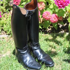 a pair of black boots sitting in the grass