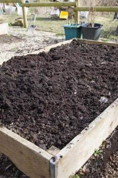 a raised garden bed filled with dirt and plants