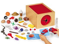 a child's hand playing with a wooden toy set