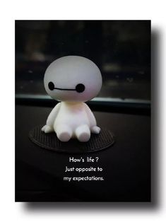 a small white toy sitting on top of a car dashboard with the caption how's life? just opposite to my expectations