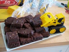 brownies are stacked up on a plate with a toy bulldozer