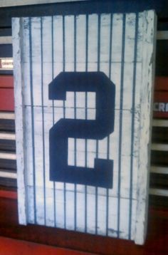 the number two is painted on a wooden sign