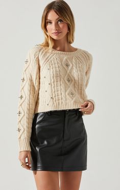 Cozy up in this stylishly chic Madison cable knit sweater! With a classic cable knit pattern and cream hue, this luxurious sweater promises warmth and style. Whether you're bundling up for winter weather or curling up with a blanket and a cup of cocoa, this sweater ensures comfort and looks-at-a-glance! Cropped Sweaters, Rhinestone Sweater, Embellished Sweater, Cream Knit Sweater, Leather Skirts, Embellished Sweaters, Sweater Cream, Cable Stitch, Knit Sweaters