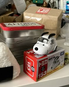 a small toy dog sitting on top of a box next to other toys and boxes