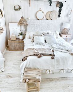 a bed with white linens and pillows in a room decorated with wicker baskets