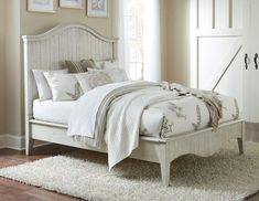 a white bed sitting on top of a wooden floor