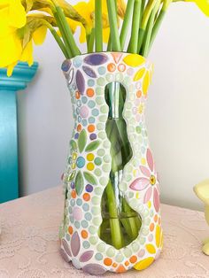 a vase filled with yellow flowers on top of a table