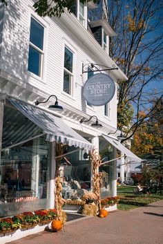 a store front with pumpkins on display outside