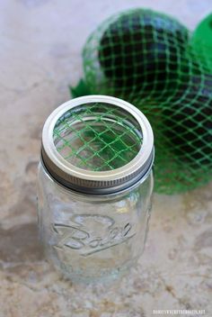 two green mesh bags sitting next to a mason jar