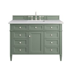 a green bathroom vanity with two sinks and white counter tops on the top, against a white background