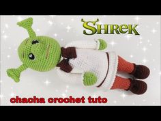 a crocheted stuffed animal laying on top of a white surface with the words shrek above it