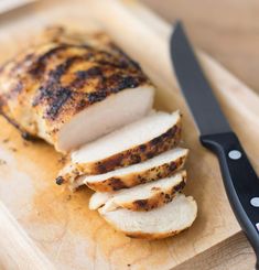 a sliced chicken on a cutting board with a knife