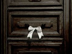 a white bow on the handle of a wooden door