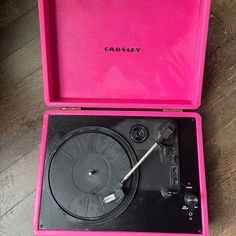 a pink record player in its case on the floor