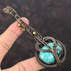 Note : Due to the natural formation of this gemstone. Slight variation in design and color are to be expected.  Tibetan Turquoise Pendant Copper Wire Wrapped Gemstone Pendant Unique Copper Wire Jewelry Handmade Guitar Pendant Turquoise Jewelry For Gift Handmade Copper Pendant SKU : VFWP-383 Gemstone : Tibetan Turquoise Stone Shape : Oval    Metal Purity : Copper Pendant Length : 115 MM   Pendant Width : 45 MM It is also believed that Tibetan Turquoise will bring happiness and good fortune to its owner if it was given by a loving hand, it is sympathetic not only to the wearer's health but also to the giver. It is believed that Turquoise will become paler in colour if he or she is threatened by evil. Unique Round Turquoise Necklace With Adjustable Fit, Handmade Turquoise Necklace Nature-inspired, Handmade Nature-inspired Turquoise Necklace, Handmade Turquoise Necklace, Nature-inspired, Bohemian Copper Wire Pendant Jewelry, Wire Wrapped Guitar Pendant, Blue Turquoise Wire-wrapped Necklace Gift, Guitar Pendant, Spiritual Hand-wrapped Copper Wire Necklace