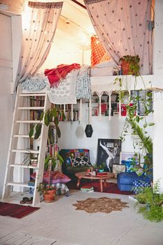 a loft bed with curtains and plants in it