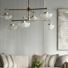 a living room filled with furniture and a chandelier hanging from the middle of it