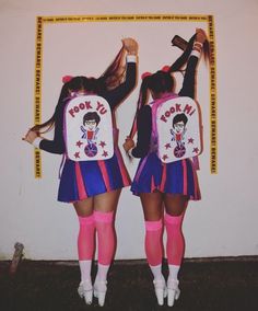 two girls dressed in cheerleader outfits are standing next to each other