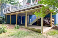 a house with blue siding and stairs leading up to the second story deck that is covered in wood