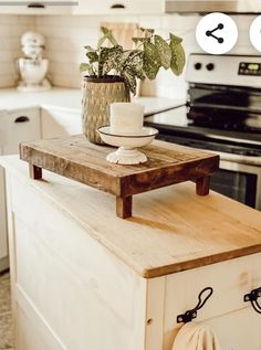 a potted plant sitting on top of a wooden shelf in a kitchen next to an oven