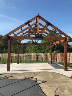 a wooden gazebo sitting in the middle of a yard