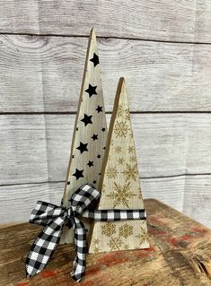 two wooden christmas trees with black and white bows