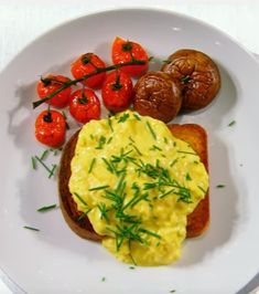 a plate with eggs, tomatoes and toast on it