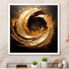 an abstract painting in gold and black on a wall